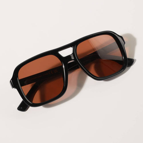 Black sunglasses with brown lenses on a white background
