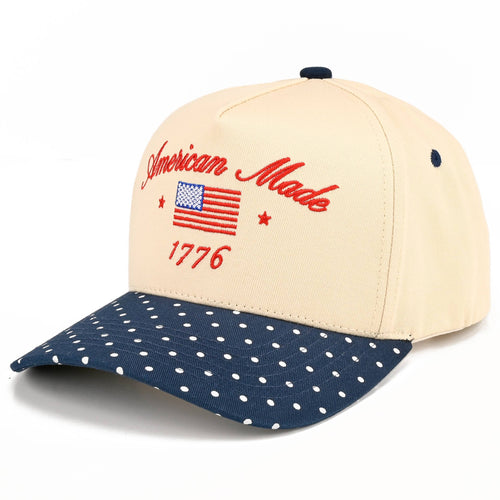 Cap with 'American Made 1776' text and American flag design on beige and navy blue polka dot pattern.