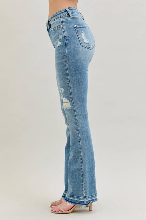 Light blue jeans with distressed details on a plain background