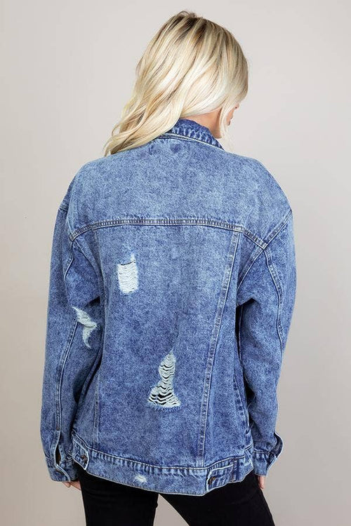 Woman wearing a blue denim jacket on a plain background
