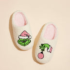 Pair of slippers with Grinch design on a beige background