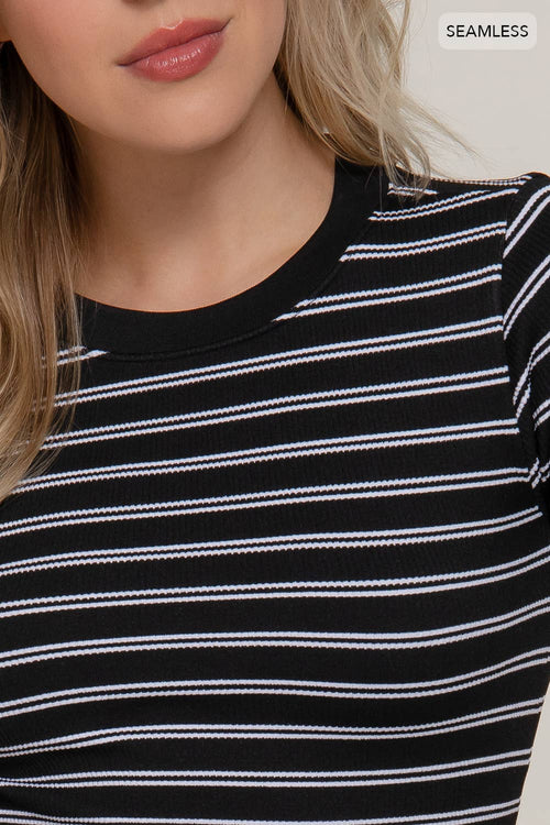 Close-up of a person wearing a black and white striped shirt with a 'Seamless' label.