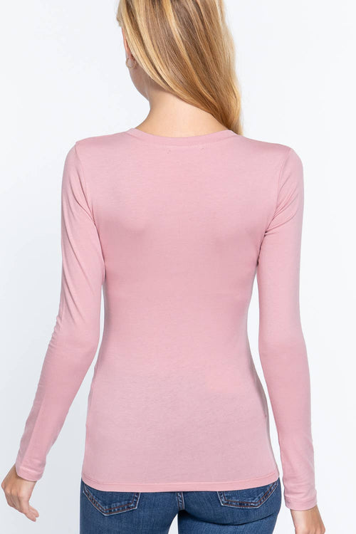 Person wearing a pink long-sleeve top on a white background