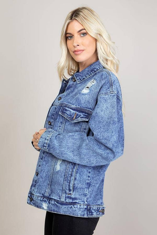 Woman wearing a blue denim jacket on a plain background