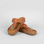 Pair of brown sandals with turquoise stones on white background