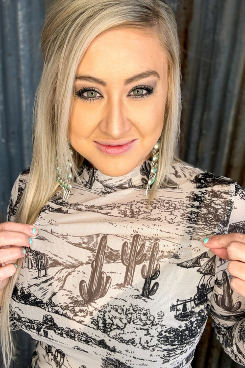 Woman holding up a patterned fabric with anchor design against a neutral background