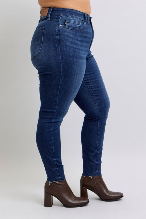 Person wearing blue jeans and brown boots on a white background