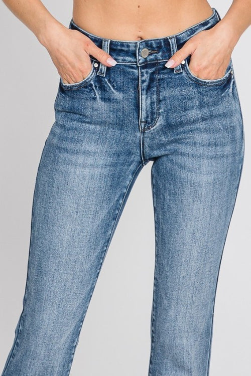 Blue jeans worn by a person on a gray background