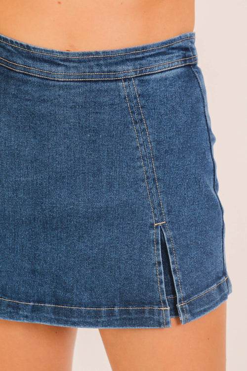 Close-up of a blue denim skirt on a neutral background
