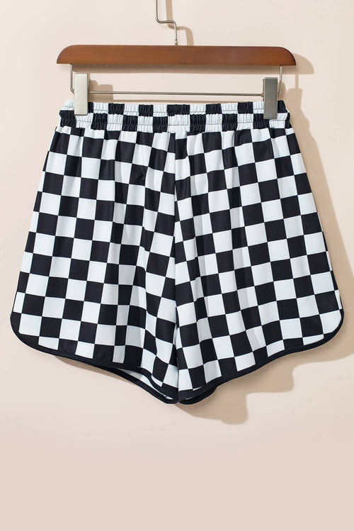 Black and white checkered shorts on a hanger against a beige background