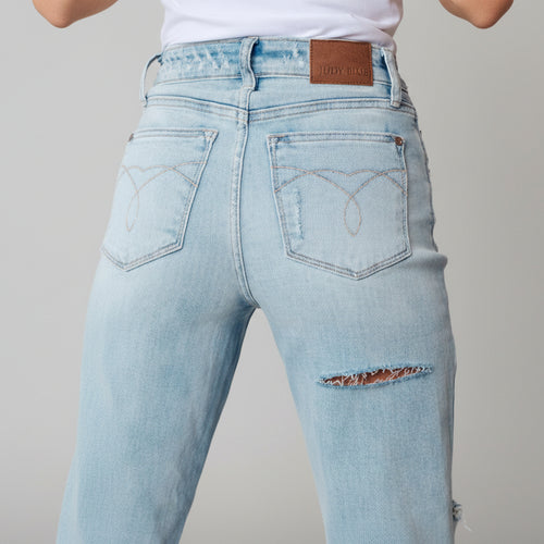 Light blue jeans with a brand label on a neutral background