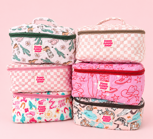 Set of pink and patterned cosmetic bags on a pink background