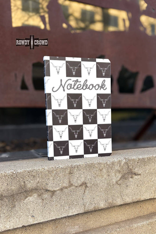 Checkered notebook with bull head pattern on a concrete surface