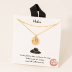 Gold necklace on a 'Halos' branded card with text and a black cowboy hat illustration.
