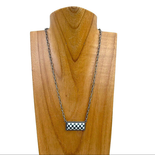 Necklace with a checkered pendant on a wooden stand