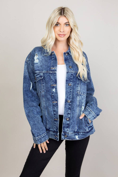 Woman wearing a blue denim jacket on a plain background