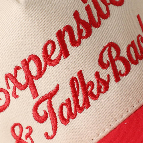 Close-up of red embroidered text on a beige background