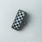 Rectangular object with a checkered pattern on a light gray background