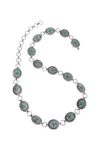 Necklace with circular metal and turquoise stone beads on a white background
