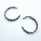 Pair of hoop earrings with turquoise stones on a white background