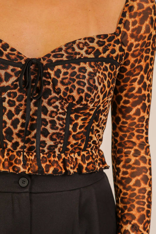 Leopard print top with long sleeves and a button detail on a neutral background