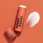 Lip balm with 'Poppy & Pout' branding on an orange background