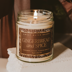 Candle in a jar labeled 'Gingerbread and Spice' by Sweet Water Decor on a white surface.