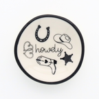 Round ceramic coaster with cowboy-themed illustrations on a white background