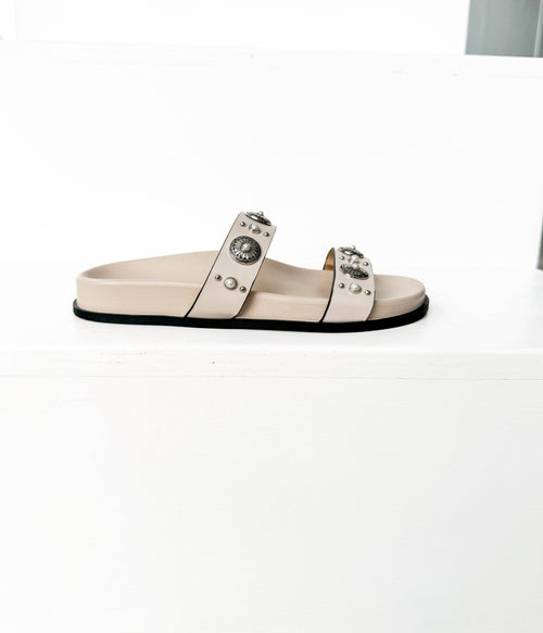 Beige sandal with embellishments on a white background