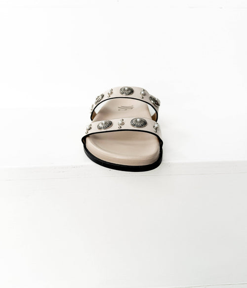 Black sandal with heart embellishments on a white background