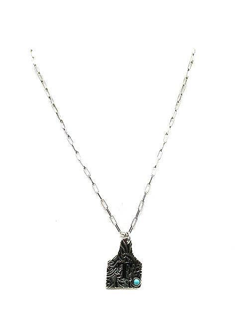Necklace with a T and turquoise stone on a white background
