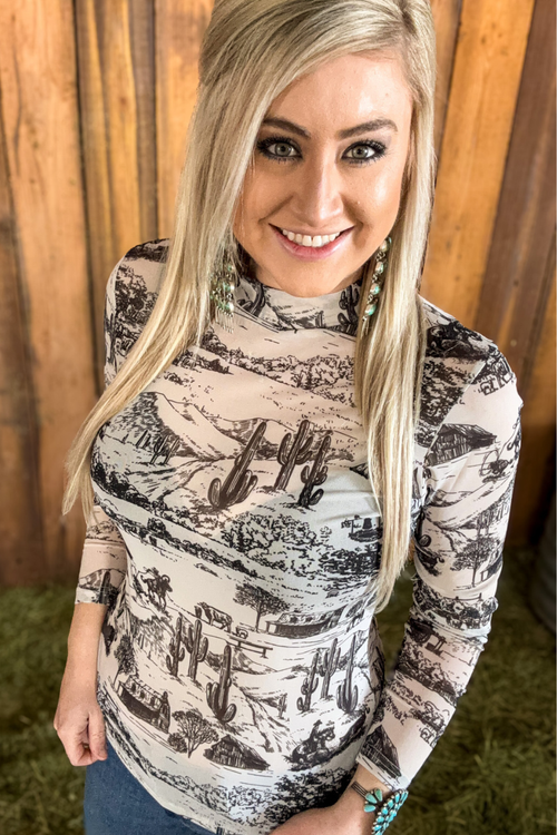 Woman wearing a long-sleeve shirt with a black and white pattern against a wooden background