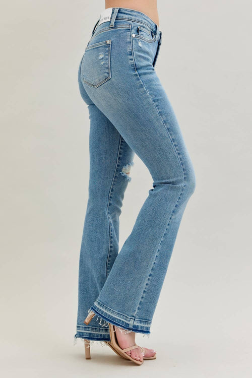Blue jeans worn by a person on a plain background
