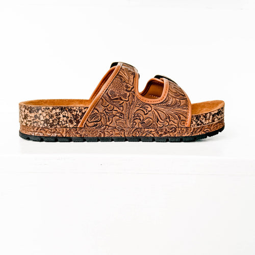Brown sandal with intricate design on a white background