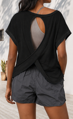Person wearing a black oversized t-shirt and gray shorts with a neutral background