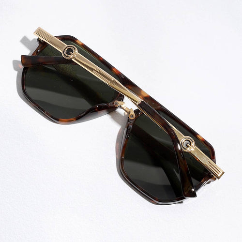 Sunglasses with tortoiseshell frame and gold accents on a white background