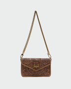 Brown leather handbag with chain strap on a light gray background