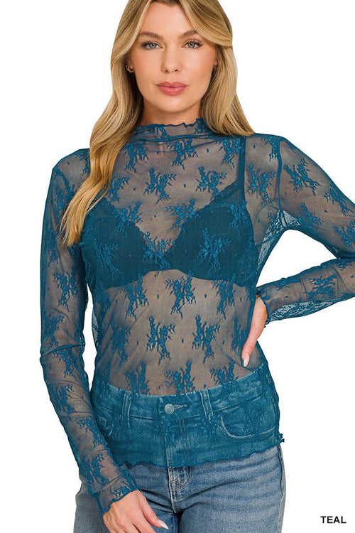 Woman wearing a teal sheer long-sleeve top with blue jeans on a white background