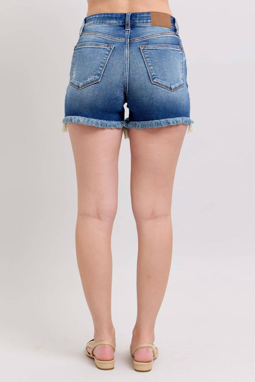 Blue denim shorts worn by a person on a white background
