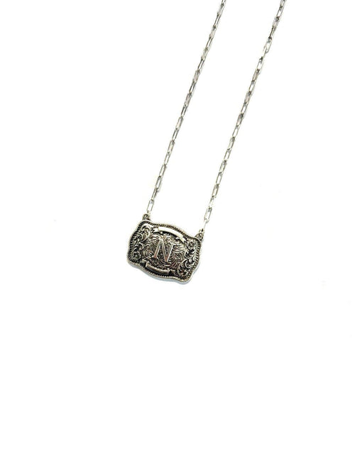 Silver necklace with a detailed pendant on a white background