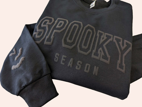 black crewneck with spooky season wrote on it on white background