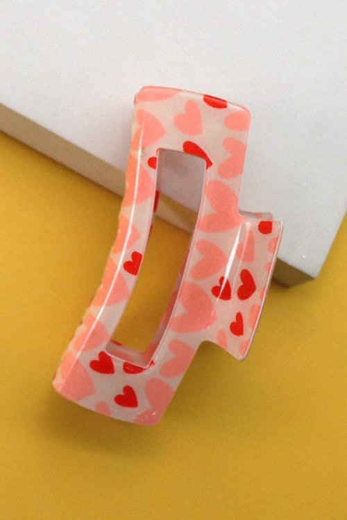 Hair clip with heart pattern on a yellow and white background