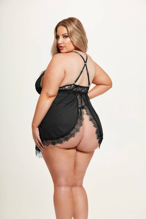 Woman wearing a black lace lingerie set on a plain background