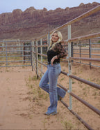 Women leaning on fence wearing boots