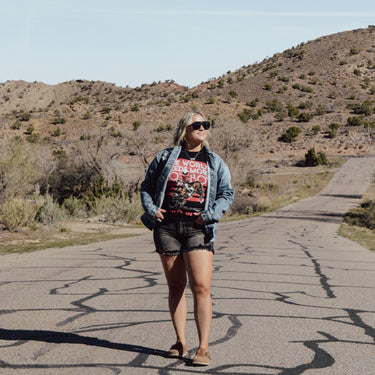 Person standing on a road with a mountainous landscape in the background