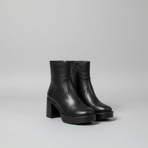Black ankle boots with a white background