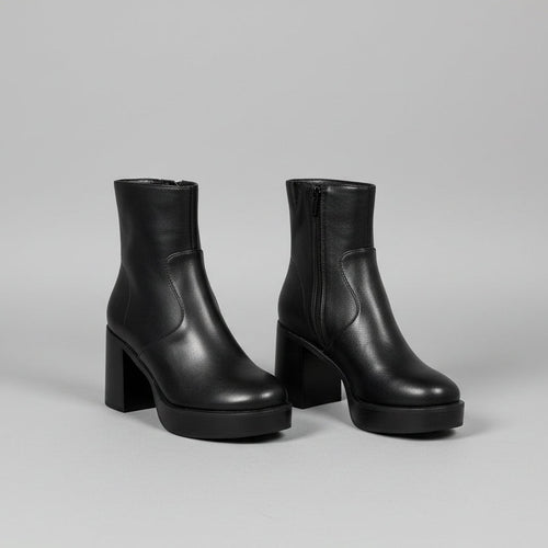 Black ankle boots with a white background
