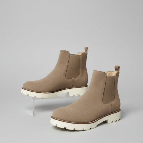 Pair of brown Chelsea boots on a light gray background