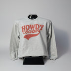 Gray sweatshirt with 'HOWDY COWBOY' text on a mannequin against a white wall.