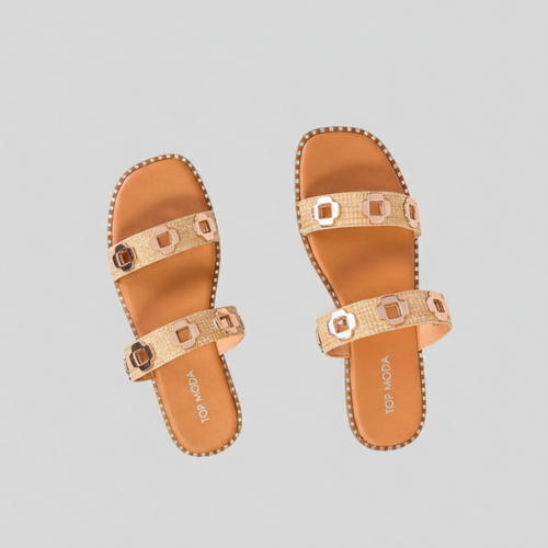 Pair of tan sandals with decorative straps on a light gray background
